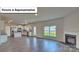 Open-concept living space with a fireplace, white cabinets, and stainless steel appliances at 8067 Kennesaw Dr, Gastonia, NC 28056