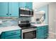 Modern kitchen featuring turquoise cabinets, stainless steel appliances, and white countertops at 969 Copperstone Ln, Fort Mill, SC 29708