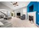 Open living room with a fireplace, gray couches, a ceiling fan, and plenty of natural light at 969 Copperstone Ln, Fort Mill, SC 29708
