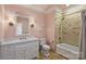 Cozy bathroom with tiled shower and tub, vanity, and charming sconces at 1012 Clover Crest Ln, Weddington, NC 28104