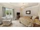 Comfortable bedroom with a patterned chair, a large window, and neutral decor at 1012 Clover Crest Ln, Weddington, NC 28104