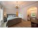 Serene bedroom featuring soft pink walls, a tufted bed, and elegant lighting at 1012 Clover Crest Ln, Weddington, NC 28104