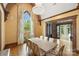 Spacious dining room with large windows offering beautiful outdoor views, complemented by hardwood floors and chandelier at 1012 Clover Crest Ln, Weddington, NC 28104