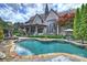 Elegant brick home with a beautiful pool, lush landscaping, and a charming outdoor living space at 1012 Clover Crest Ln, Weddington, NC 28104