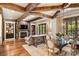 Open-concept living space featuring exposed beams, a stone fireplace, and a connected dining area at 1012 Clover Crest Ln, Weddington, NC 28104