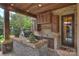 Covered outdoor kitchen with brick accents and built-in grill area at 1012 Clover Crest Ln, Weddington, NC 28104