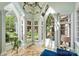 Bright sunroom showcasing large arched windows, elegant trim, and a view of lush landscaping at 1012 Clover Crest Ln, Weddington, NC 28104