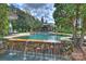 Beautiful swimming pool with integrated waterfall feature and surrounding lush landscaping, ideal for relaxation at 1012 Clover Crest Ln, Weddington, NC 28104