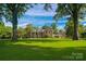 Expansive green lawn with stately brick home, featuring a covered walkway connecting to a guest house at 1035 Pee Dee Ave, Albemarle, NC 28001