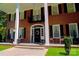 Inviting front porch with black shutters, white pillars, and a 