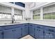 This kitchen offers white subway tile backsplash, blue cabinetry, and plenty of natural light at 105 Deaver St, Chester, SC 29706