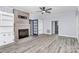 Open living room featuring a brick fireplace, built-in shelves, and modern ceiling fan at 105 Deaver St, Chester, SC 29706