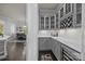 Elegant bar area with gray cabinets, wine rack, and beverage fridge, perfect for entertaining at 10904 Kilkenny Dr, Matthews, NC 28105