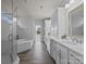 Bathroom featuring a glass door shower, white tub, and vanity at 10904 Kilkenny Dr, Matthews, NC 28105