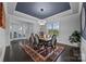 Bright dining room with a dark tray ceiling, modern chandelier, and hardwood floors at 10904 Kilkenny Dr, Matthews, NC 28105