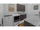 Functional laundry room with modern appliances, granite countertops, and cabinet storage at 10904 Kilkenny Dr, Matthews, NC 28105