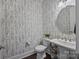 Stylish powder room featuring elegant wallpaper, pedestal sink, and modern fixtures at 10904 Kilkenny Dr, Matthews, NC 28105