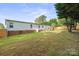 Sprawling backyard features mature trees, a well-maintained lawn, complemented by a charming outdoor deck area at 115 Oak Creek Rd, Statesville, NC 28625