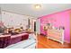 A unique bedroom with a playful pink color scheme, personalized decor, and hardwood flooring at 115 Oak Creek Rd, Statesville, NC 28625