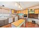 A modern kitchen featuring wood cabinets, appliances, and a center island with butcher block top and wood laminate floors at 115 Oak Creek Rd, Statesville, NC 28625