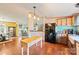 An open kitchen featuring stainless steel appliances, a breakfast bar, and wood laminate floors that flow into the dining area at 115 Oak Creek Rd, Statesville, NC 28625