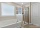 Modern bathroom featuring a sleek bathtub and separate glass-enclosed shower, providing a luxurious spa-like experience at 116 Rainbow Trout Trl, Fort Mill, SC 29715