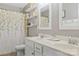 Bathroom vanity with double sinks, decorative curtain, open shelving, and a neutral color palette at 116 Rainbow Trout Trl, Fort Mill, SC 29715
