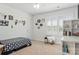 Bedroom with geometric bedding, a bench, and floating shelves, all illuminated by natural light from shuttered windows at 116 Rainbow Trout Trl, Fort Mill, SC 29715