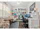 Well-lit home office featuring custom shelving, stylish decor, and a comfortable work environment at 116 Rainbow Trout Trl, Fort Mill, SC 29715