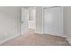 This carpeted bedroom has white trim, an open door, and a closet at 13712 Bonnerby Ct, Huntersville, NC 28078