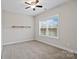 This carpeted bedroom has a ceiling fan, a shelf, and a window at 13712 Bonnerby Ct, Huntersville, NC 28078
