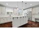 Bright, white kitchen with stainless steel appliances, pendant lighting, and dark hardwood floors at 13712 Bonnerby Ct, Huntersville, NC 28078