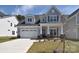 Charming two-story home boasts a manicured lawn, stone accents, and a welcoming entrance at 1378 Cedardale Ln, Denver, NC 28037