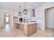 Bright kitchen boasts a center island with a marble countertop and modern, stainless steel appliances and pendant lighting at 1378 Cedardale Ln, Denver, NC 28037