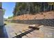 Outdoor patio with stone pavers, retaining wall, landscaped backyard, and stone fire pit at 1378 Cedardale Ln, Denver, NC 28037
