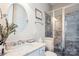 Updated bathroom with a marble countertop, glass shower and modern fixtures at 15402 Country Lake Dr, Pineville, NC 28134