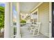 Inviting front porch with rocking chairs and classic white columns offers a relaxing outdoor space at 15402 Country Lake Dr, Pineville, NC 28134