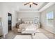 Bright main bedroom boasts tray ceiling, bench seat, tufted headboard, and large windows with plenty of natural light at 15402 Country Lake Dr, Pineville, NC 28134