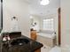 A well-lit bathroom featuring granite countertops, a soaking tub, and dark fixtures at 1736 Cavendale Dr, Rock Hill, SC 29732