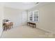 Bright, carpeted room featuring a bench seat below a window and a printer on a wooden table at 1736 Cavendale Dr, Rock Hill, SC 29732