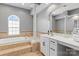 Bathroom features tub with tile surround, large mirror and stylish vanity at 1840 Sapona Ct, Denver, NC 28037