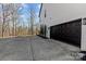 A house featuring a black garage door and a driveway lined with trees at 1840 Sapona Ct, Denver, NC 28037