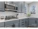 The updated kitchen features stainless steel appliances, marble countertops, and grey cabinets at 1840 Sapona Ct, Denver, NC 28037