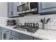 The updated kitchen has stainless steel appliances, marble countertops and gray cabinets at 1840 Sapona Ct, Denver, NC 28037