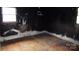 Damaged interior view featuring a room with peeling black paint, wooden floor, and window at 1842 Quail Run Dr, Kingstown, NC 28150