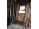 Damaged bathroom area with visible wall studs and window, indicating fire damage and need for renovation at 1842 Quail Run Dr, Kingstown, NC 28150