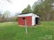 Exterior view of a shed showcasing its block construction, door, and grassy surroundings at 1842 Quail Run Dr, Kingstown, NC 28150
