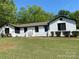 Inviting painted brick home features a bright blue front door, lush lawn, and manicured landscaping under a clear blue sky at 1946 Fairway Dr, Lancaster, SC 29720
