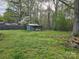 Backyard view highlighting the lush green grass, storage shed, and surrounding trees at 2021 Hilton Way Rd, Lancaster, SC 29720