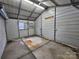 Inside the storage building in the carport, you can see a concrete floor and metal siding walls at 2021 Hilton Way Rd, Lancaster, SC 29720